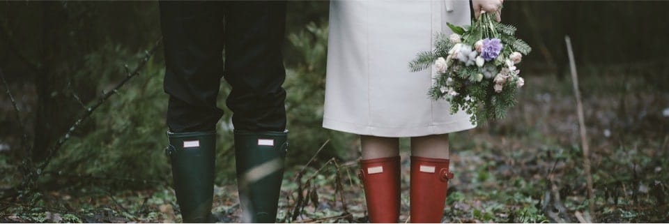 Man and woman in wellington boots stood in a forest