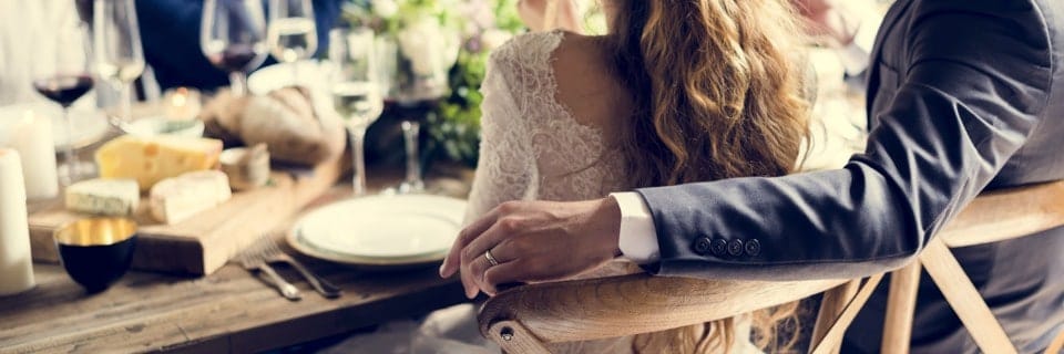 Man and woman with their around each other sat at a restaurant