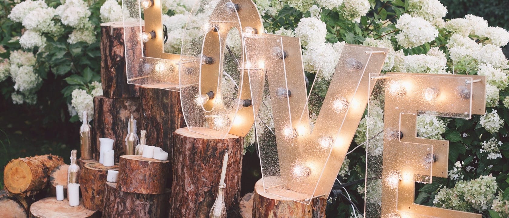 Large LOVE sign lit up in a garden scene