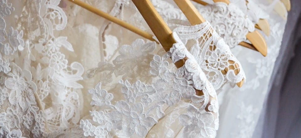 Wedding dresses lined up on a rack