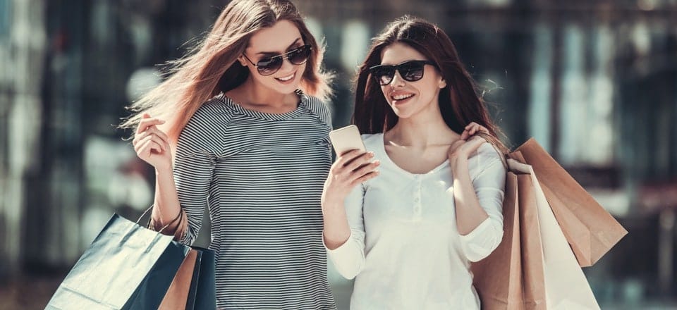 Two friends carrying multiple shopping bags