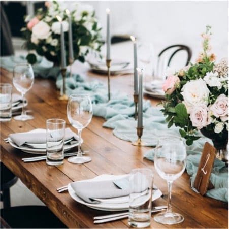 Wooden table set out nicely with plates and flowers
