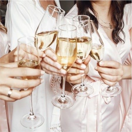 Women in a circle touching champagne glasses