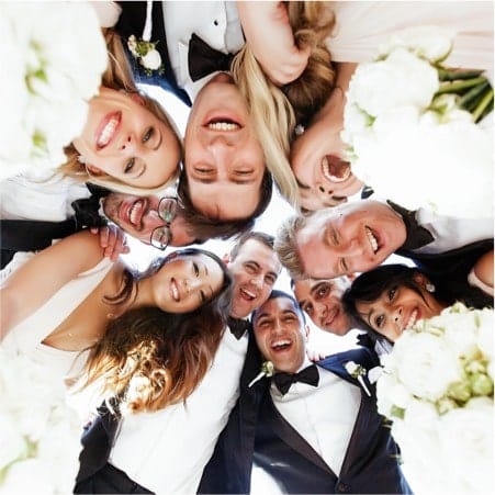 Group of people in a huddle looking down onto the camera