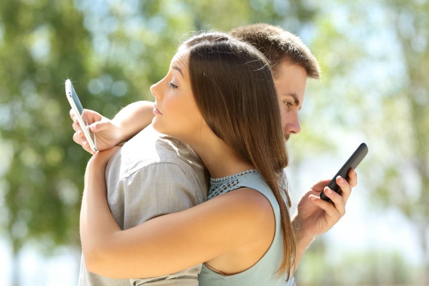 Image of couple checking phones