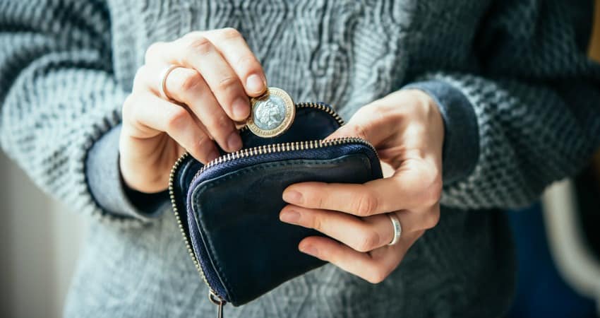 Image of woman putting savings in purse
