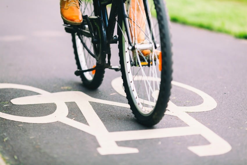 Image of someone cycling to cut down on costs