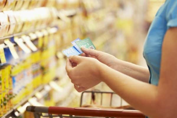 Woman using coupons at supermarket
