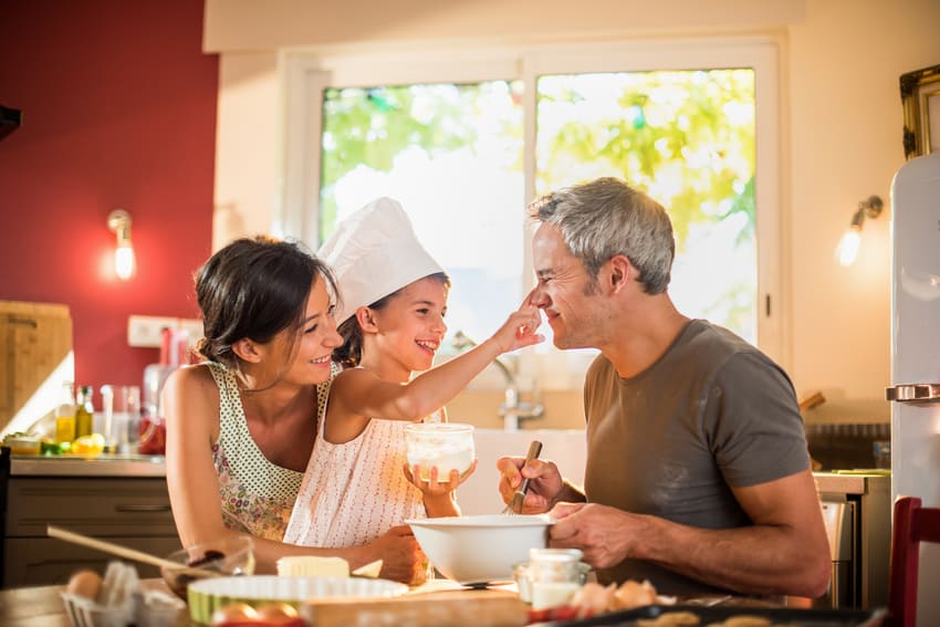 Mum Dad and daughter cooking together baking together family time