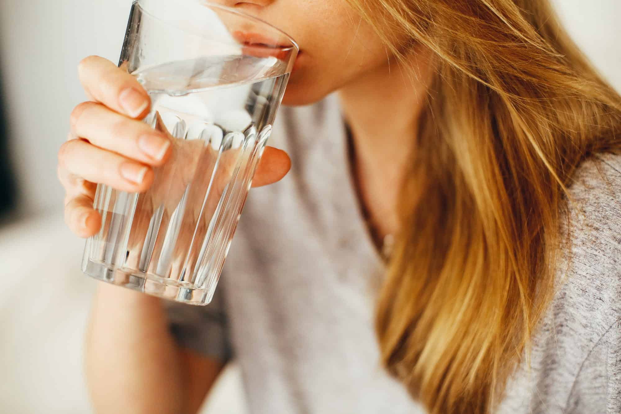 brown haired woman drinking water