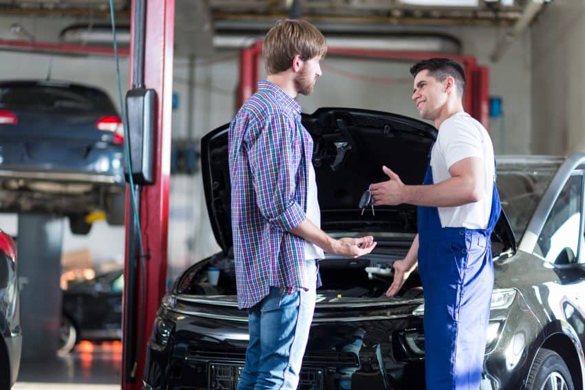 Two men in a garage car repairs