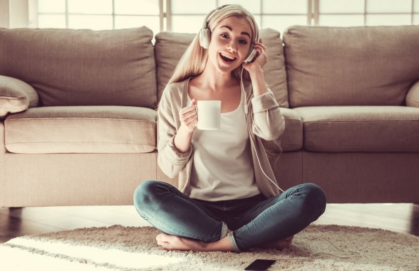 Woman listening to sounds of music on floor