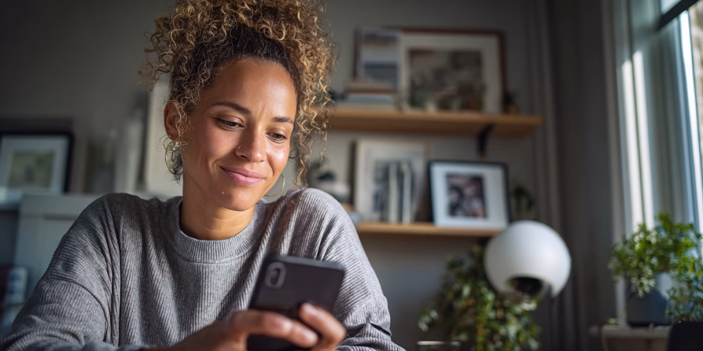 Woman reviewing £200 loan options on laptop at home in UK kitchen