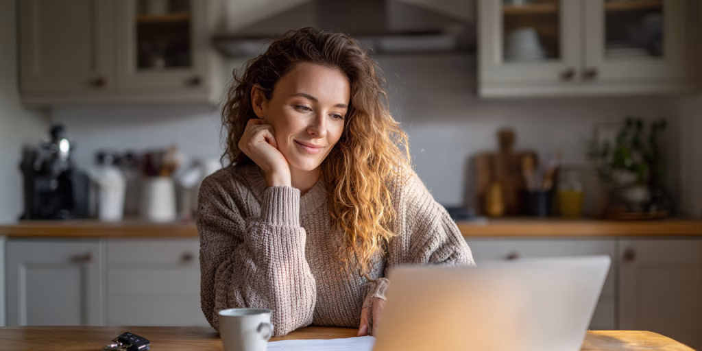 British woman reviewing £1500 loan options on laptop at home