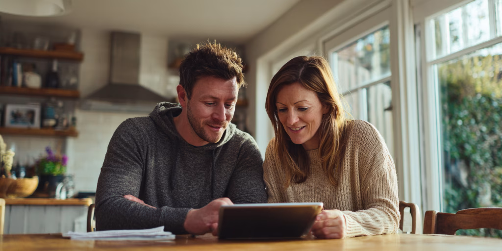 Couple comparing 300 pound loan alternatives on tablet in UK home